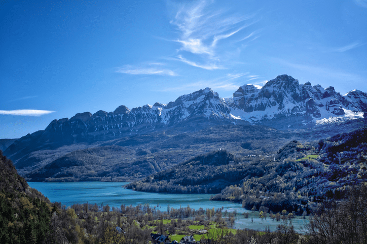 Snow-capped peaks above turquoise lake and village