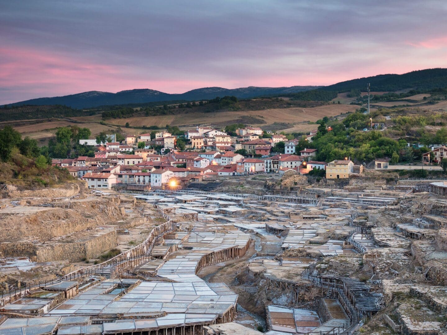 Terraced salt pans leading to village at sunset