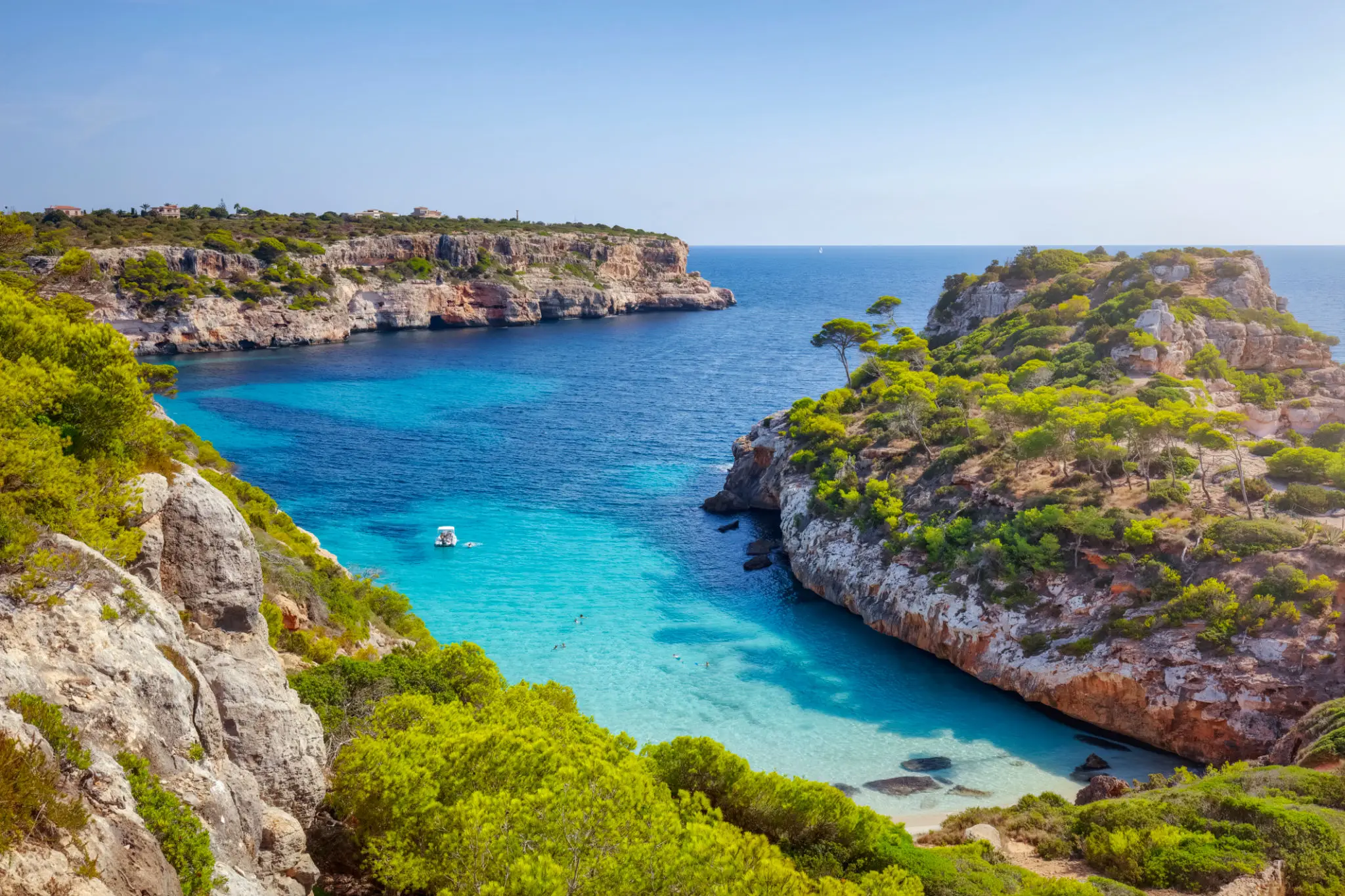 Turquoise cove with rocky cliffs and boat
