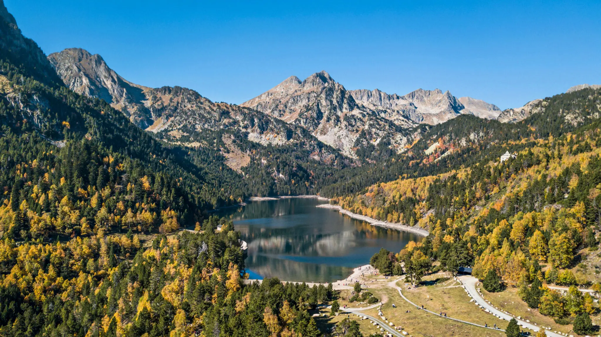 Alpine mountain lake surrounded by autumn forest