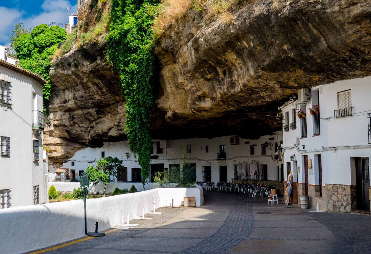 White houses built beneath rocky cliff overhang