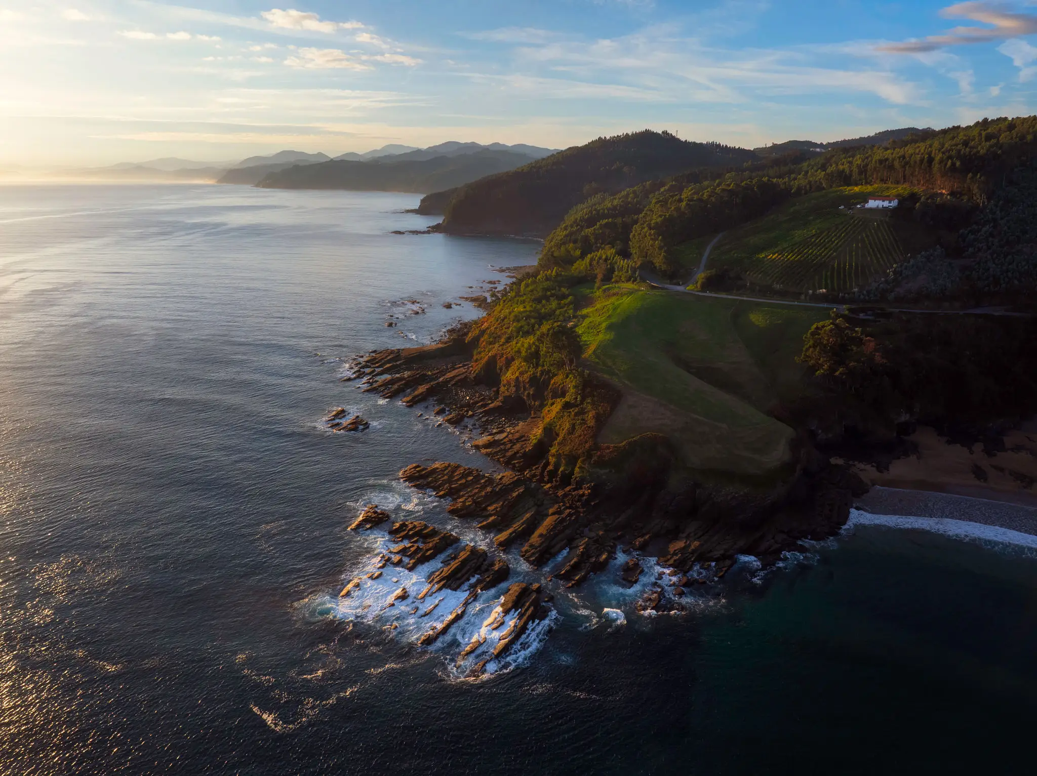 Sunlit coastal headland with rocky shoreline