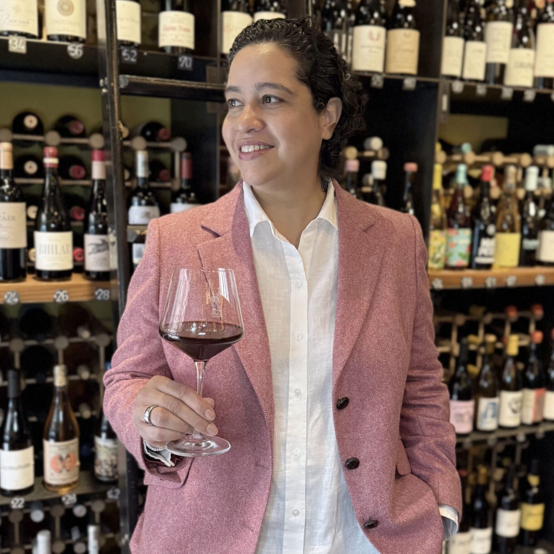 Person tasting red wine in wine shop