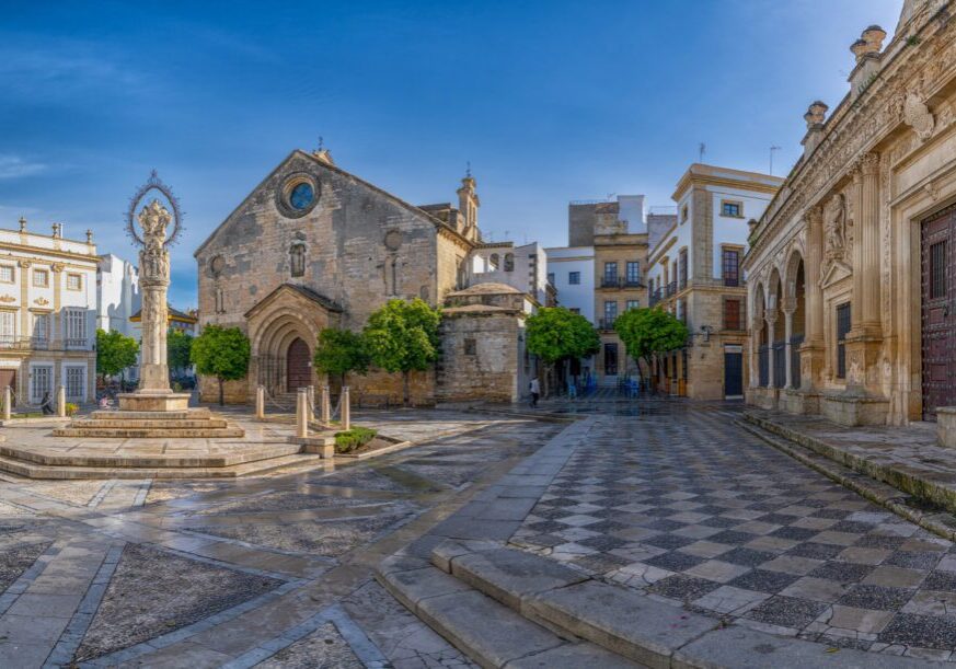 Sunlit historic plaza with church and fountain