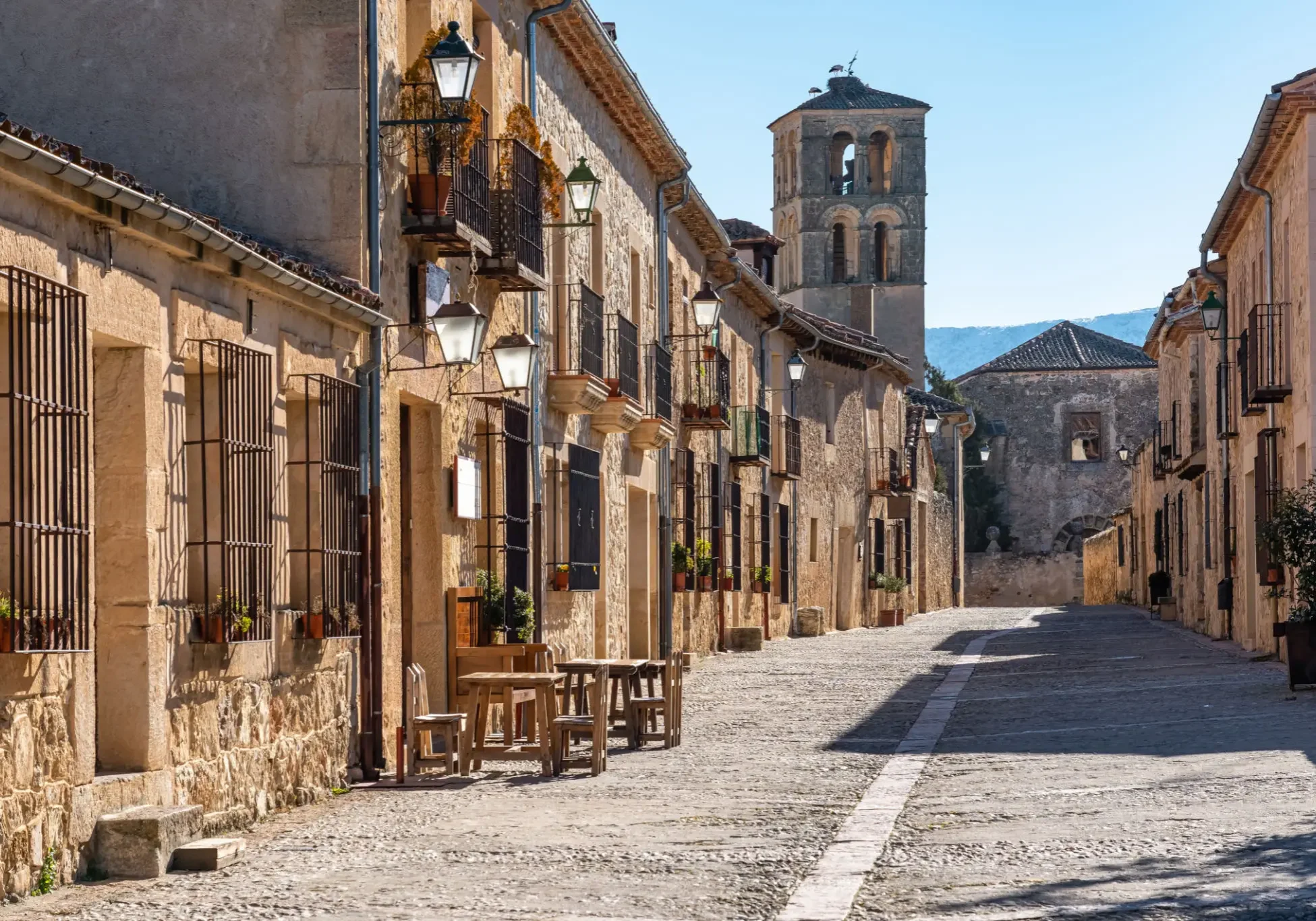 Sunlit cobblestone street in historic Spanish village